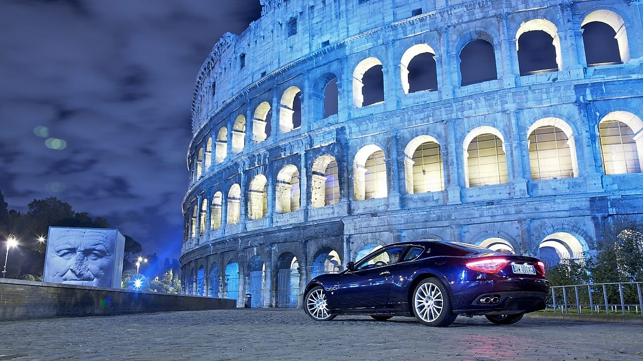 Auto negro por la noche delante del Coliseo