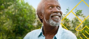 Hombre sonriente con barba delante de unos árboles con un resumen del gráfico de generación de valor para el accionista