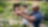Hombre ayudando a un niño sonriente a regar plantas en un jardín
