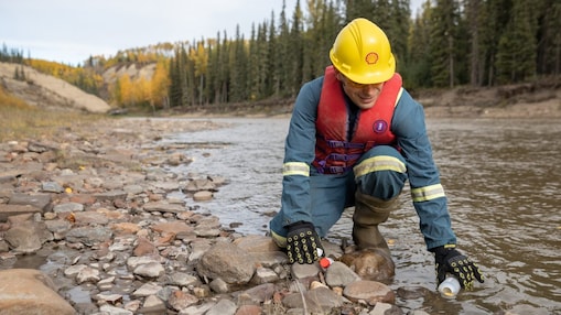 Empleado de Shell recogiendo agua del río