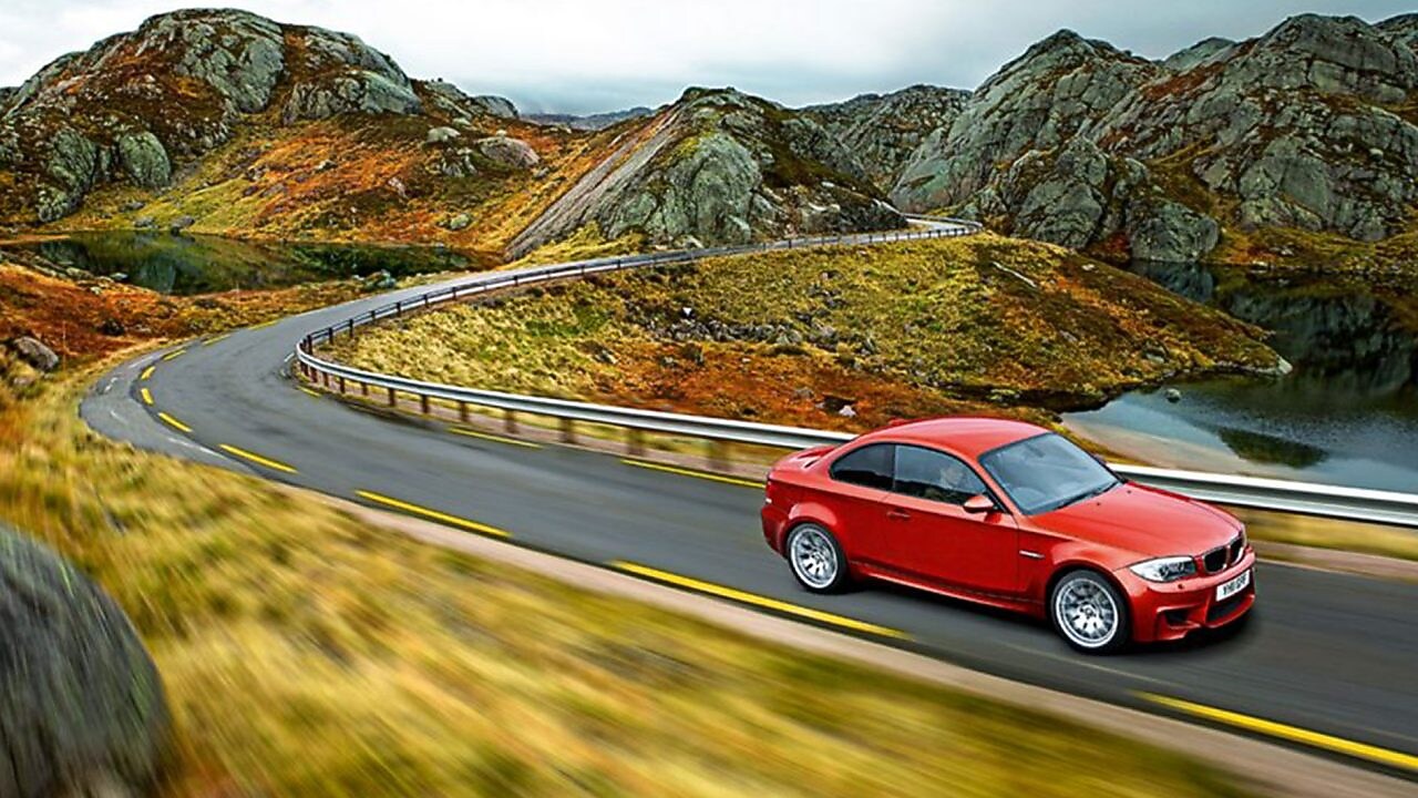 Sedan rojo circulando por la ruta en Noruega
