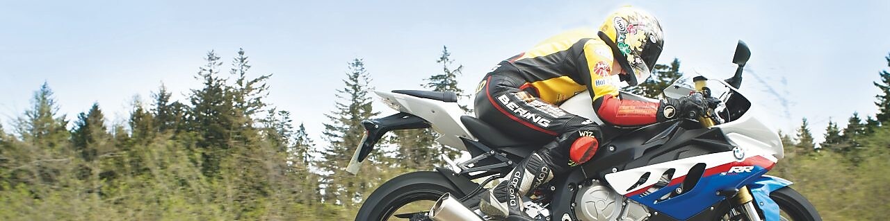 Hombre conduciendo una moto por una ruta nacional