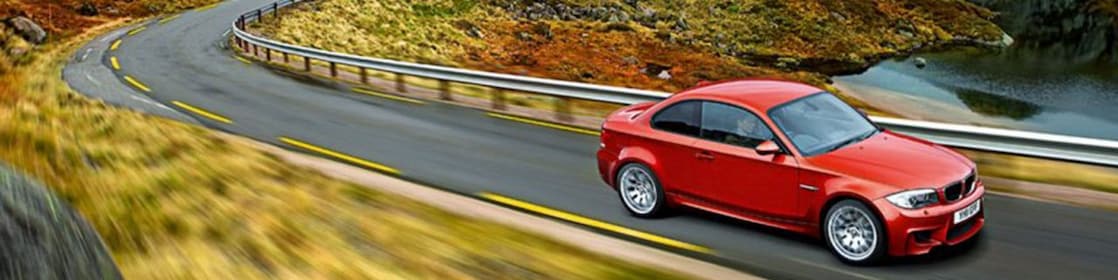 Sedan rojo circulando por la ruta en Noruega