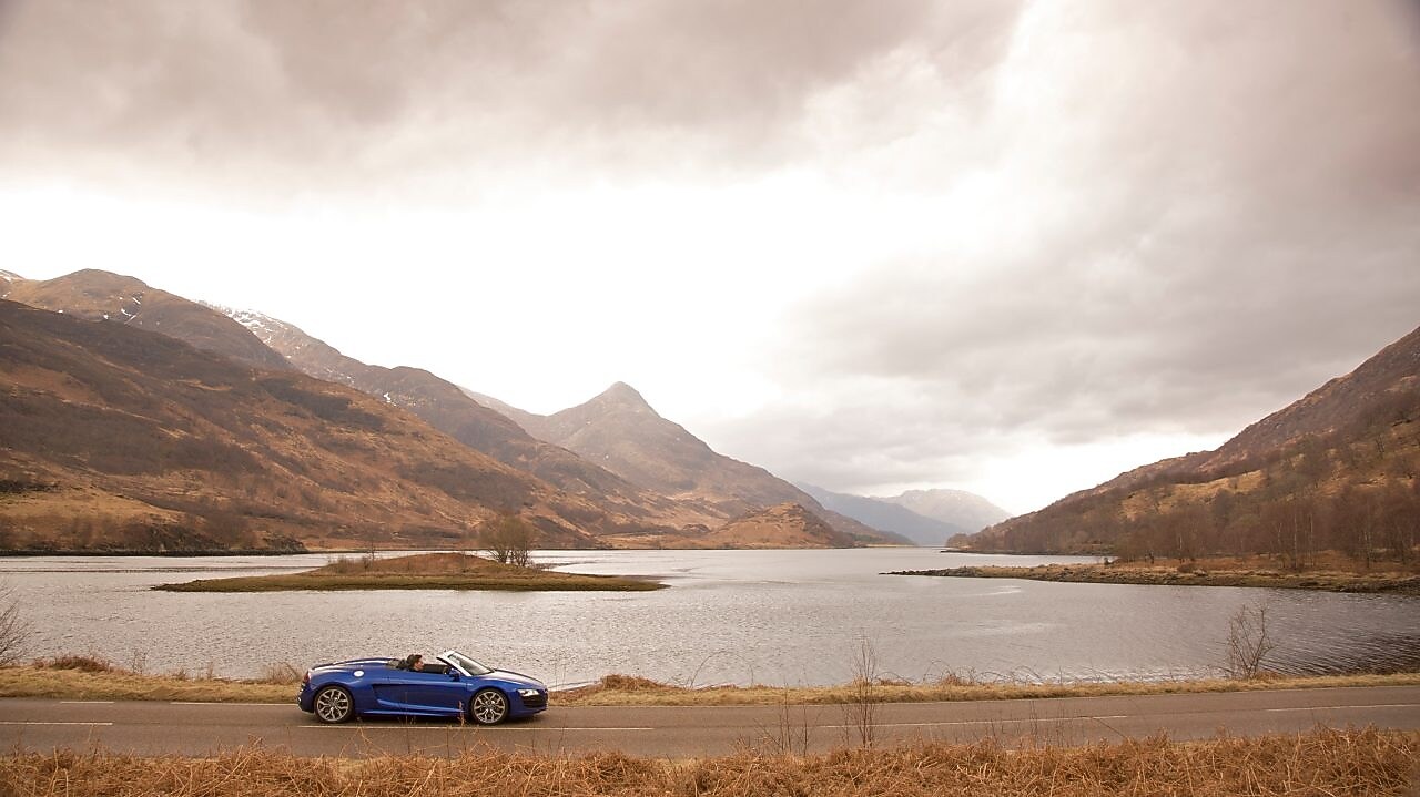 Auto en la ruta junto a un lago de montaña