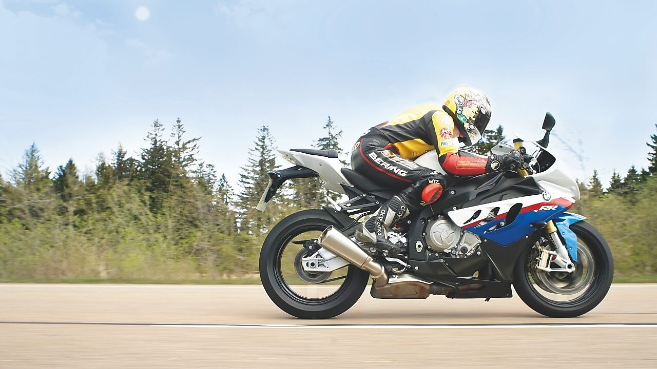 Hombre conduciendo una moto por una ruta nacional