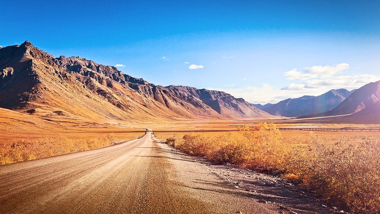 ruta desierta sin asfaltar rodeada de montañas