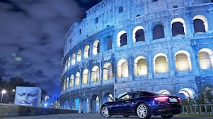 Auto estacionado en el exterior del Coliseo de Roma de noche