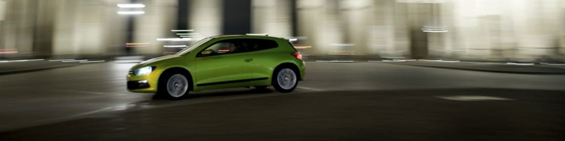 Auto verde conduciendo velozmente de noche