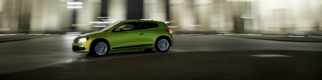 Auto verde conduciendo velozmente de noche