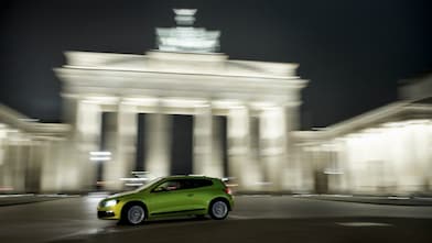 Auto verde conduciendo velozmente de noche