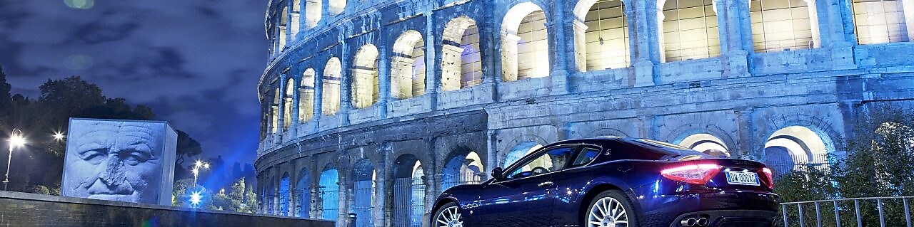 auto estacionado en el exterior del Coliseo de Roma de noche