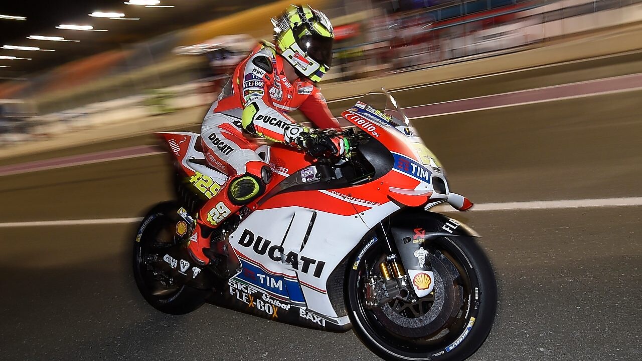 Piloto de Ducati conduciendo una moto a alta velocidad en una pista de noche