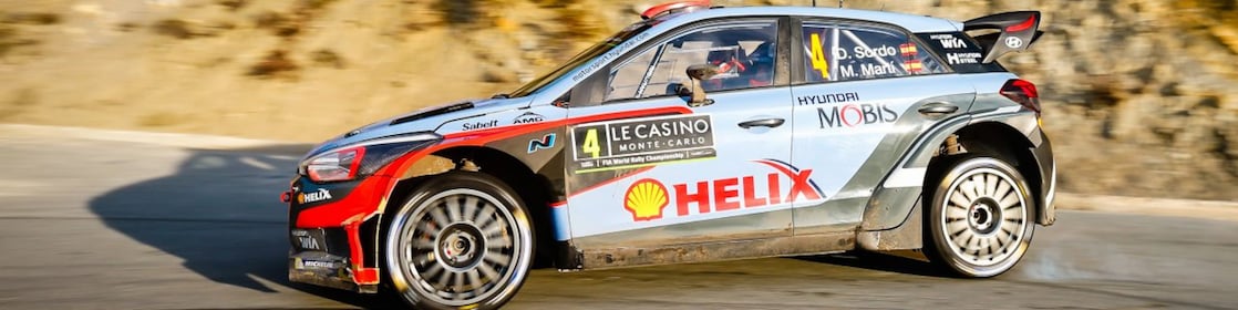 Coche de rally derrapando en una curva en el Campeonato del Mundo de Rally