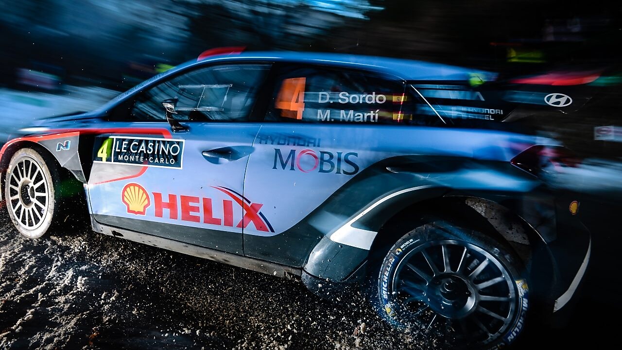 Coche de rally corriendo a gran velocidad al amanecer en el Campeonato del Mundo de Rally