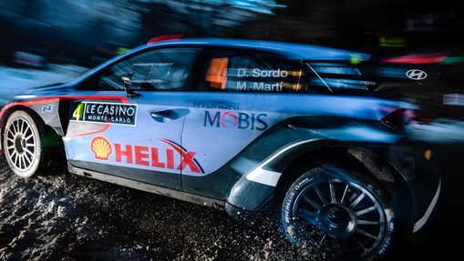 Coche de rally corriendo a gran velocidad al amanecer en el Campeonato del Mundo de Rally