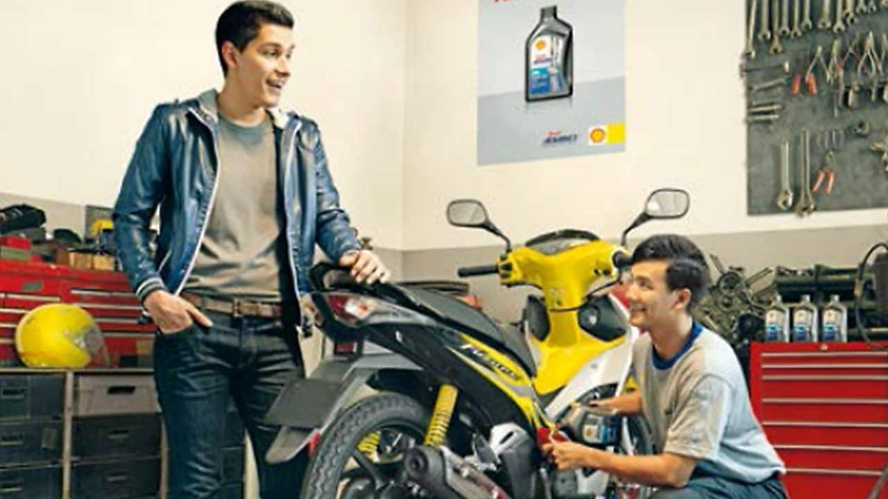 dos motociclistas cambiando el aceite de una motocicleta