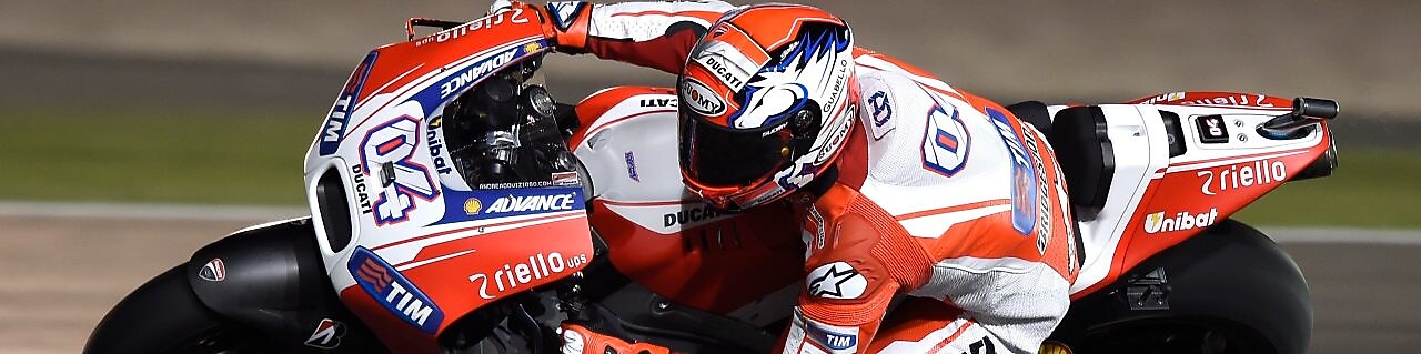 Motocicleta con piloto corriendo en una curva de una pista