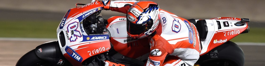 Motocicleta con piloto corriendo en una curva de una pista